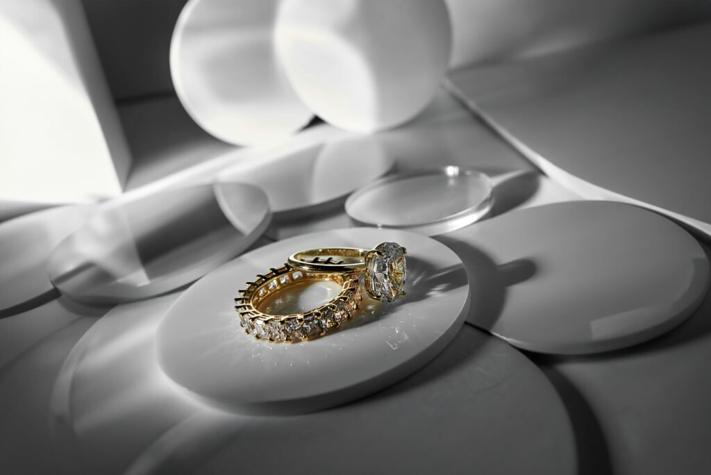 Close-up of elegant gold and diamond rings on a modern abstract surface, showcasing luxury style.